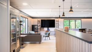 a living room with a bar and a tv at Campanile NATURE - Vannes in Vannes