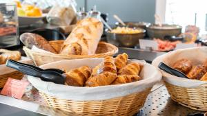 a bunch of baskets of bread and pastries on a counter at Campanile NATURE - Vannes in Vannes