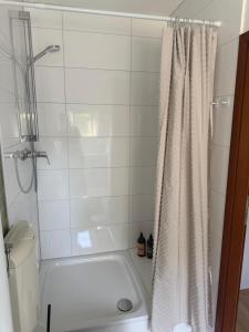 a bathroom with a white shower curtain and a toilet at Heimathafen Neumünster in Neumünster