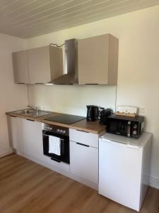 a kitchen with a stove and a microwave at Heimathafen Neumünster in Neumünster