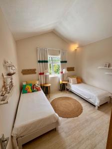 a bedroom with two beds and a window at Villa Kanasuk in Pointe d'Esny