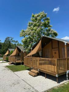 a row of wooden huts with trees in the background at Glamping Terme Tuhelj in Tuheljske Toplice