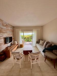 a living room with a couch and a table and chairs at Villa Kanasuk in Pointe d'Esny