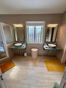 a bathroom with two sinks and two mirrors at Villa Kanasuk in Pointe d'Esny +22 photos