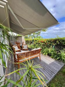 a wooden deck with chairs and an umbrella at Villa Kanasuk in Pointe d'Esny