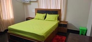 a bedroom with a bed with green sheets and pillows at Smiley Homestay in Varkala