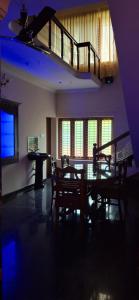 a living room with a table and a staircase at Smiley Homestay in Varkala