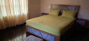 a bedroom with a large bed with yellow pillows at Smiley Homestay in Varkala