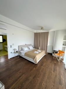a bedroom with a large bed and wooden floors at Coastal Pool Hideaway in Loukísia