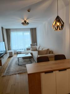 a living room with a couch and a table at Modern Riverside Apartment in Sarajevo +13 photos