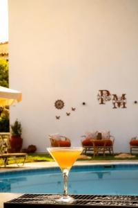 a drink sitting on a table next to a swimming pool at Pavlos Maria studios in Skiathos