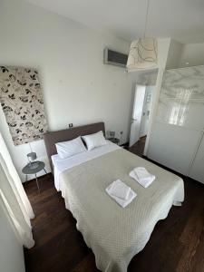 a bedroom with a bed with two towels on it at Coastal Pool Hideaway in Loukísia +2 photos