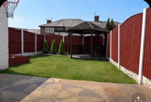 a backyard with a gazebo and a fence at Piotr House in Warrington
