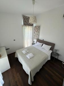 a bedroom with a large bed with two towels on it at Coastal Pool Hideaway in Loukísia