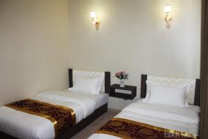two beds in a room with white walls and lights at Tsetsenkhangai Hotel in Ulaanbaatar +10 photos