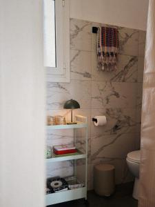 a bathroom with a toilet and a white shelf at Sun Garden House Athens in Nea Makri +27 photos