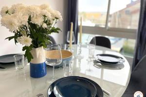 a white table with a vase of white flowers on it at Temps des Cerises - Terrasse - Plage - Marina in Deauville