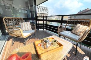 a balcony with two chairs and a table with a tray at Temps des Cerises - Terrasse - Plage - Marina in Deauville