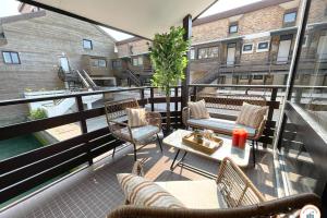 a balcony with chairs and tables on a building at Temps des Cerises - Terrasse - Plage - Marina in Deauville