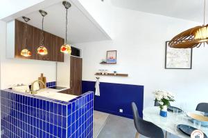 a kitchen with blue tiles on the counter and a table at Temps des Cerises - Terrasse - Plage - Marina in Deauville