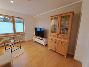 a living room with a tv and a large cabinet at Freds Ferienwohnung in Kelheim