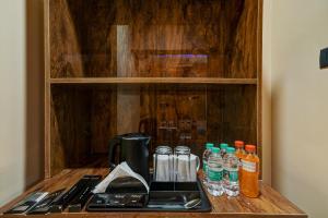 a cupboard with a coffee maker and drinks on it at Hotel Rism Suites Koramangala in Bangalore