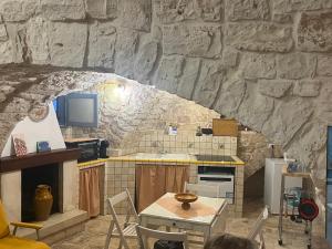 a kitchen with a table and a stone wall at La casetta di Franci in Castellana Grotte