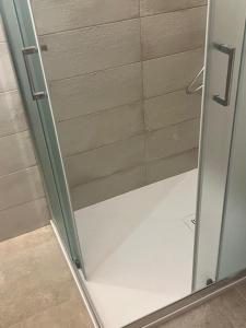 a shower stall with a glass door in a bathroom at La casetta di Franci in Castellana Grotte +4 photos