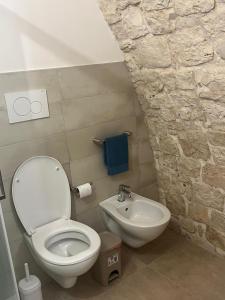 a bathroom with a white toilet and a sink at La casetta di Franci in Castellana Grotte