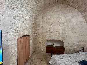 a bedroom with a bed in a stone wall at La casetta di Franci in Castellana Grotte