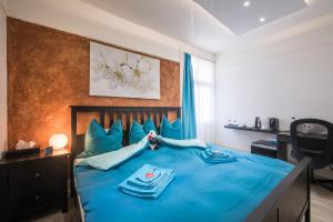 1 dormitorio con 1 cama azul con sábanas azules en Max Aviation Villa & Apartments en Berna