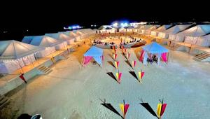 a group of tents with kites in the water at night at Quba Desert Camp Jaisalmer in Jaisalmer