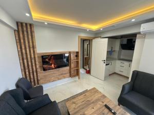 a living room with two chairs and a fireplace at Benan Apart Otel Didim in Didim