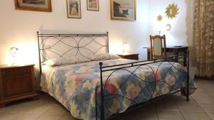ピサにあるアルフィエーリ ベッド ＆ ブレックファーストのベッドルーム1室(カラフルな掛け布団付きのベッド1台付)