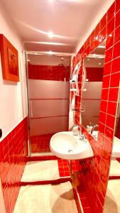 a red tiled bathroom with a sink and a mirror at Casa Doina in Baile Felix +108 photos