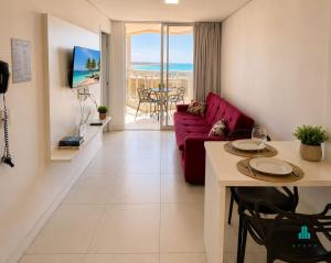 a living room with a red couch and a table at Aquarius Residence by Holiday Stays in Fortaleza
