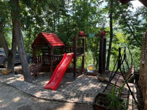 a playground with a red slide and a gazebo at Etnokutak Milojevic in Paraćin
