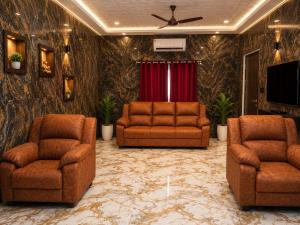 a living room with two chairs and a television at CG Blue Horizon Villa in Vellore