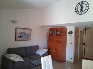 a living room with a couch and a clock on the wall at Maison Laujo en bord de mer in Santa-Maria-Poggio
