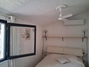 a bedroom with a ceiling fan and a bed at Maison Laujo en bord de mer in Santa-Maria-Poggio