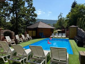 a swimming pool with chairs and a girl in a float at Etnokutak Milojevic in Paraćin