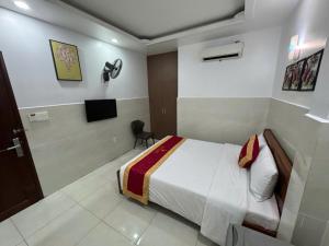 a bedroom with a bed and a television in it at Hotel Bros in Ho Chi Minh City