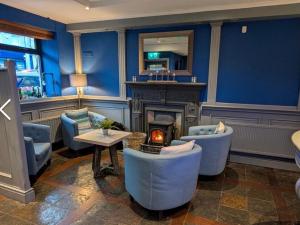 a living room with blue walls and chairs and a fireplace at The Bridge in Ballyconnell