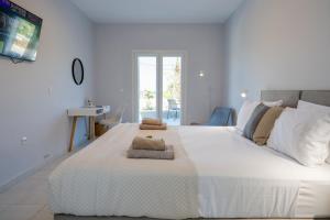 a bedroom with a large white bed with two towels on it at Pachynammos Studios & Apartments in Kypseli +20 photos