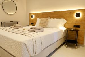 a bedroom with a large white bed with a mirror at Pachynammos Studios & Apartments in Kypseli