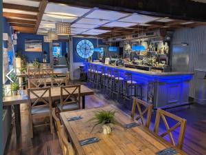 a restaurant with wooden tables and a blue bar at The Bridge in Ballyconnell