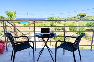 a table with a laptop on it on a balcony at Pachynammos Studios & Apartments in Kypseli