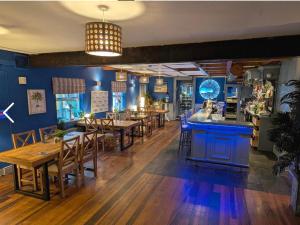 a restaurant with blue walls and wooden tables and chairs at The Bridge in Ballyconnell