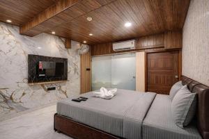 a bedroom with a large bed in a room with a fireplace at Hotel Rism Suites Koramangala in Bangalore