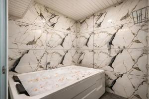 a bathroom with a white and black marble wall at Hotel Rism Suites Koramangala in Bangalore
